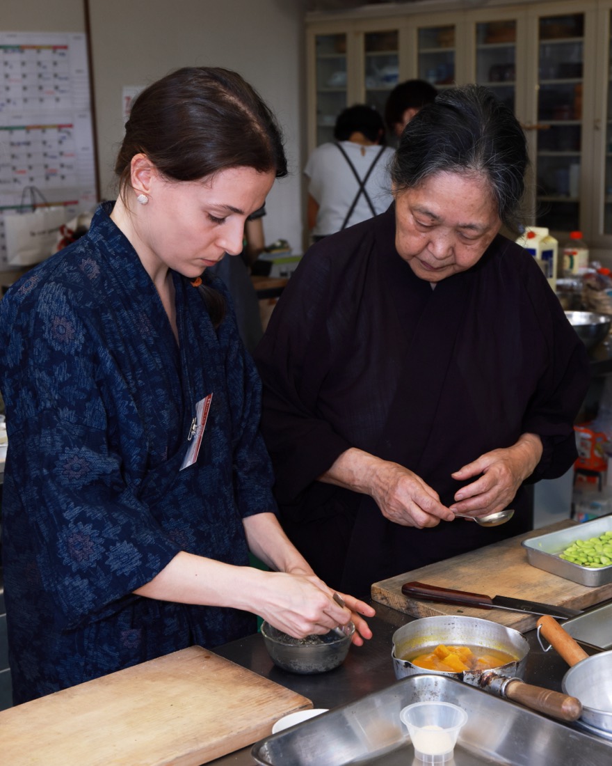 厨房で、西井香春が参加者に手ほどきをしている